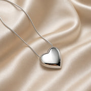 Elegante collar con colgante de corazón abombado en oro blanco